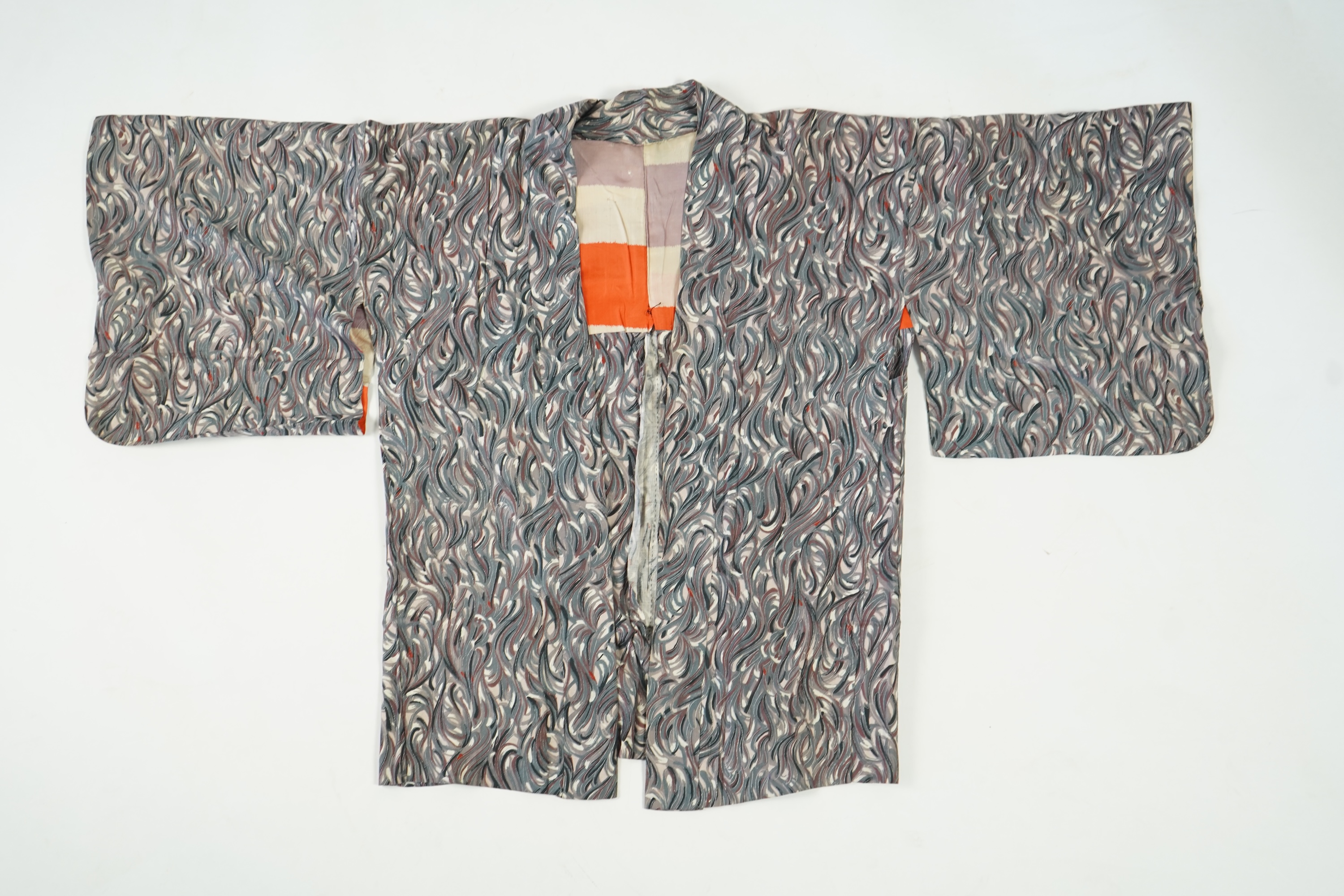 Three Japanese mid 20th century ‘Haori’ printed silk jackets. One red with brightly coloured lining and rust brown floral silk lining. All with large kimono sleeves. Grey patterned Haori, 79cm long., Condition - good